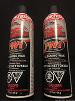 Two cans of FW1 Wash & Wax High Performance Cleaning Wax with Carnauba for automotive surfaces, front labels showing usage and hazard warnings.