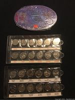 Top view of 1999 Canada millennium quarters in purple collectible packaging with 12 quarters visible in clear plastic sleeve labeled by month and design.