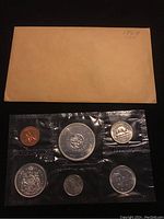 Three images showing each of the three 1964 Canadian uncirculated coin sets, each sealed in clear plastic with the original brown envelope backing.
