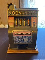 Front view of Bonanza Bank piggy bank resembling a slot machine with reels and coin images.