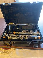 Open case displaying the disassembled Artley clarinet inside with mouthpiece and keys visible, resting on black velvet lining.