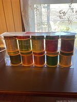 Front view of the box containing 20 curling ribbon spools arranged in two rows showing different colors and sizes.