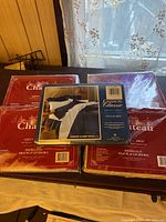 Lot of multiple double sheet sets including a Cannon Classic navy blue solid set in original packaging on top of other boxed sheets