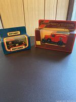 Two Matchbox collectible toy vehicles in original packaging, one is a red 1930 Ford Van Canada Post model and the other a black Ford Model A.
