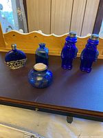 Full lot of five small blue glass items including various shaped jars and Planters salt and pepper shakers