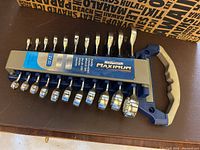 Top view of 11-piece Mastercraft Maximum stubby metric combination wrench set in plastic storage holder with handle.