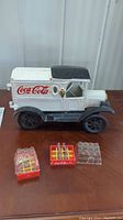 Overall lot: white and black cast iron model Coca-Cola delivery truck with three plastic crates and miniature bottles
