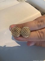 Front view of both round cufflink faces showing woven texture and polished rim