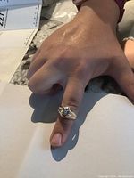 Ring worn on thumb showing top view of star motif setting and center diamond