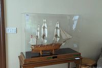 Front view of entire model ship in plexiglass case on wood table