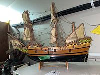 Front angle view of wooden sailing ship model with detailed rigging and painted hull patterns.