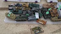 Top-down view of the collection of military model tanks, armored vehicles, and some figurines placed on a clear tote lid.