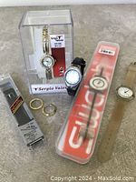 Lot showing all watches and accessories including Sergio Valenti watch in packaging, black band watch, Swatch watch in packaging, beige band watch, bezels, and replacement strap.