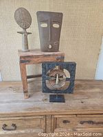 Lot on wooden surface against textured cloth backdrop. Shows small wooden stool with three sculptural decor items.