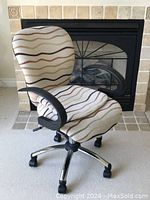 Front angle of the office chair showing upholstery, cushion split, and base with wheels.