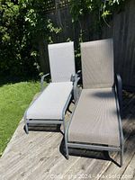 Two chaise lounges on wood deck under sunlight