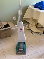 Front view of Bissell QuickSteamer carpet cleaner showing branding, transparent scrub head, and white body.