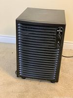 Front view of black Kenmore dehumidifier showing horizontal vents and control dials