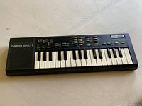 Front view of Casio SK-1 keyboard showing keys, function buttons, speaker, and labels.