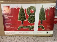 Box showing Home Accents Holiday set contents and dimensions for trees, wreath, and garlands.