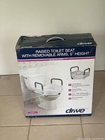 Photo of the Drive raised toilet seat in its original packaging, showing product name, features, and image of the product mounted on a toilet.