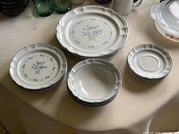 Top view of stacked plates and bowls showing floral pattern and scalloped edges