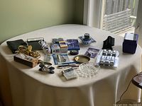 Entire lot on table showing planner, music clipboard, extension cords, roller wheels, sanding sponges, clipping light, hardware items and more