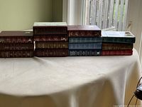 14 assorted Reader's Digest Condensed books stacked on table showing spines and covers