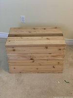 Front view of the wooden box showing natural wood finish and hinged lid.