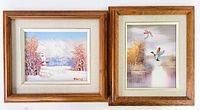 Two small framed oil paintings side by side. Left shows winter landscape with a woman in a pink and white dress; right shows ducks flying over water with brown and beige grasses.