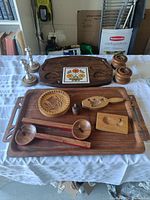 Full view of entire lot arranged on table including trays, carved molds, ladles, shakers and candlesticks