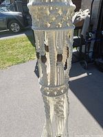 Full view of the large macrame hanging planter showing knotted cotton with wooden bead accents and wide braided rim.