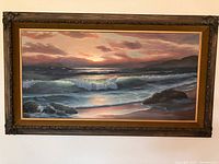 Full frontal view of framed seascape sunset painting