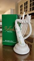 Front view of the Belleek Parian China harp figurine alongside original green box.