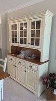 Full front view of distressed knotty pine buffet and hutch showing drawers, cupboards and glass doors