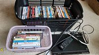 Two baskets containing DVDs and a Sony DVD player with remote on the floor.