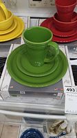Green Fiestaware bistro set showing plate, saucer, and mug on top.