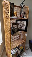 Full view of the four section wicker shelf unit with items on some shelves showing scale and detail.