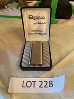 Quantum by Firebird branded lighter inside black fitted case with foam padding.