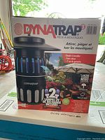 Front and side photos of boxed Dynatrap mosquito trap showing product branding, features and coverage area.