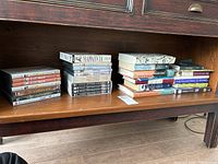Wide view of DVDs and books on shelf showing stacks of assorted books and DVD cases