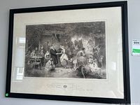 Full view of the framed black and white print depicting a wedding Eve scene, shown in a black wooden frame with off-white matting.