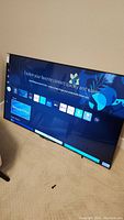 Front of TV powered on showing Samsung Smart Hub interface