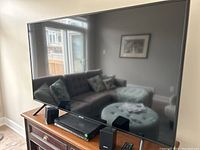 Front view of Samsung TV on console with Sony home theater main unit and two speakers in front