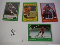 Four hockey cards featuring Garry Unger, Dennis Hull, Roy Edwards, and Stan Mikita laid on a flat surface