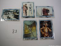 Photo of five Star Wars Empire Strikes Back trading cards showing scenes including Princess Leia, Lando's aide Lobot, and a battle preparation scene.