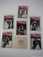Top view of six vintage hockey cards featuring Toronto Maple Leafs players Borje Salming, Vincent Damphousse, Al Iafrate, Mark Osborne, Gary Leeman, and Carl Biasatti in protective sleeves.