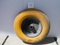 Front view of one solid core flat free tire with black center rim against a white background.