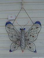 Front view of metal butterfly decor hanging on a wall.
