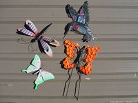 Five metal garden decor creatures displayed on wood background